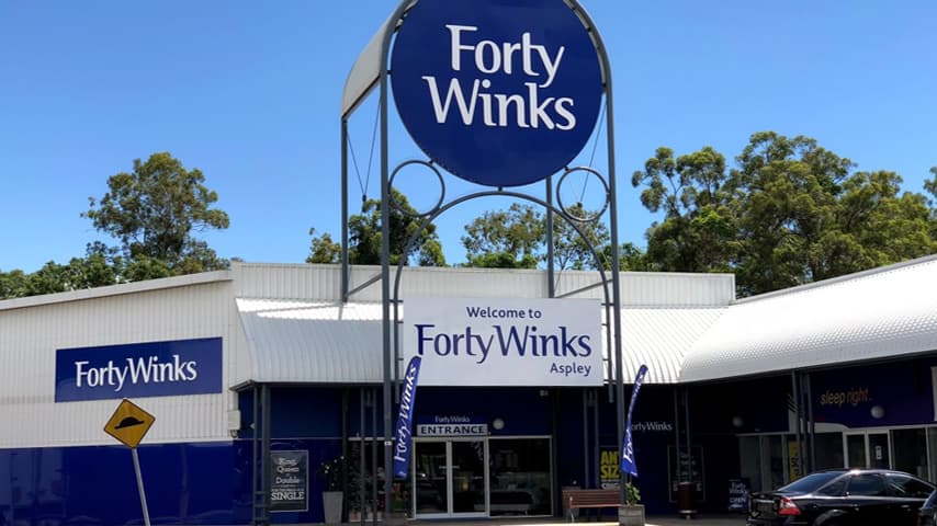 A Forty Winks sleep advisor helping customers choose a mattress at the Aspley store